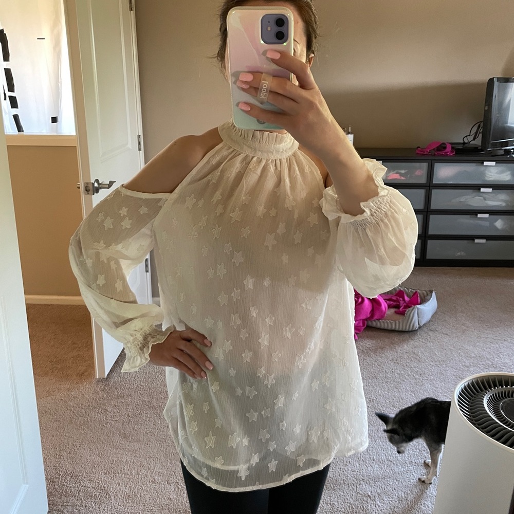 White flowy blouse with shoulder cutouts.